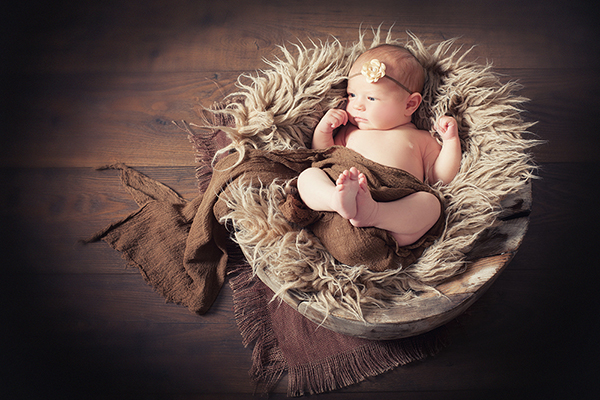 Babyfoto Düsseldorf. Baby fotografiert in Holzschale. Fotografin A. Ola Karlowski