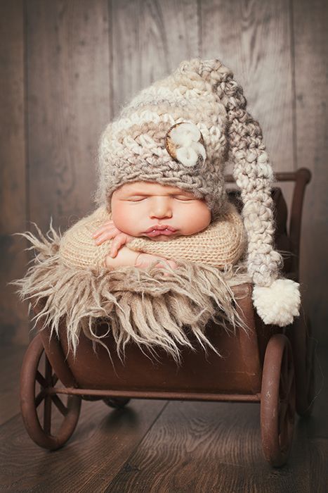 Foto mit Baby in Düsseldorf: baby ist in einem Kinderwagen weggeschlummert. Köpfchen liegt auf den Armen auf.